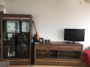 a living room with a tv and a wooden entertainment center at Şehrin mükkemel manzarası ayaklarınızın altında in Istanbul