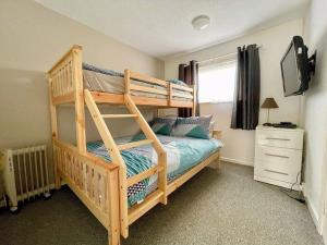 a bedroom with a bunk bed and a television at The Nest in Hemsby