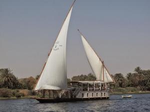a boat with two large sails on the water at Luxor Dahabiya Nile Cruise Private Family in Luxor