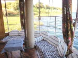 a porch on a boat with pillows on it at Luxor Dahabiya Nile Cruise Private Family in Luxor