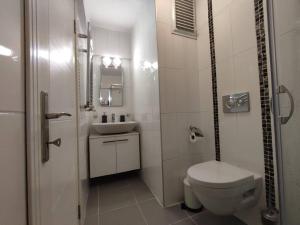 a white bathroom with a toilet and a sink at Stylish Spacious 3B Flat in Ortaköy near Bosphorus in Istanbul