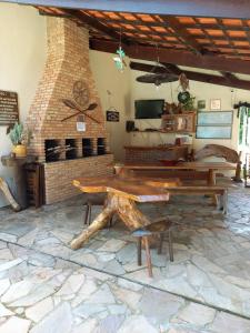 a patio with a table and a brick fireplace at Chalé da Ju in Ubatuba