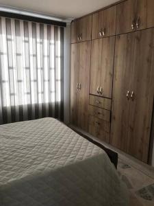 a bedroom with a bed and wooden cabinets and a window at Apartamento en el centro de Pitalito in Pitalito