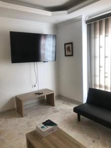a living room with a black couch and a flat screen tv at Apartamento en el centro de Pitalito in Pitalito