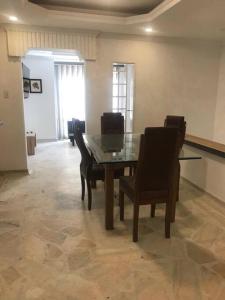 a dining room with a glass table and chairs at Apartamento en el centro de Pitalito in Pitalito