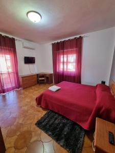 um quarto com uma cama com uma colcha vermelha em casa Gabriella em SantʼEufemia Lamezia