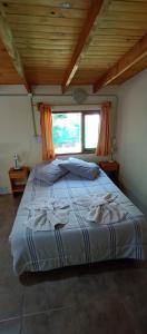 ein großes Bett in einem Zimmer mit Holzdecke in der Unterkunft Choique in San Carlos de Bariloche