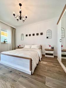 Un dormitorio con una cama grande y una lámpara de araña. en Alma Rezidence, en Turda