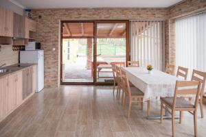 a kitchen and dining room with a table and chairs at Benige vendégház in Demjén