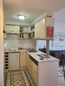 eine kleine Küche mit weißen Schränken und einem Waschbecken in der Unterkunft Espectaculares vistas in Benidorm