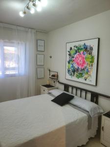 ein Schlafzimmer mit einem Bett und einem Wandgemälde in der Unterkunft Espectaculares vistas in Benidorm