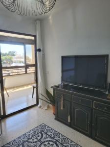 ein Wohnzimmer mit einem Flachbild-TV auf einer Kommode in der Unterkunft Espectaculares vistas in Benidorm