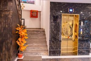un vestíbulo con escaleras y un ascensor dorado en Regal Residency en Rawalpindi