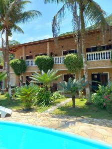 un complejo con piscina frente a un edificio en Chalé da Ju, en Ubatuba