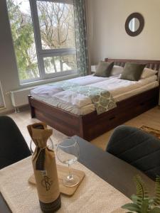 a bedroom with a bed and a table with a wine glass at Forest 57 in Sopron