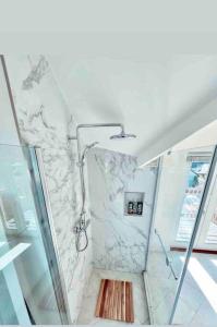a bathroom with a shower with a marble wall at The View, Kingsand, luxurious seafront penthouse apartment with sun trap balcony and incredible sea views in Kingsand