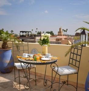 uma mesa e cadeiras sentadas numa varanda em RIAD DAR NAOMI em Marrakech