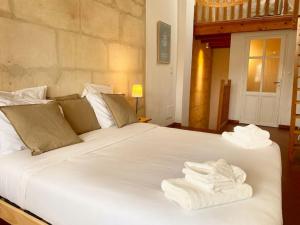um quarto com uma grande cama branca com toalhas em "La paisible" Maison vue sur le Rhône Arles em Arles