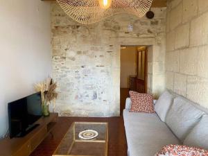 a living room with a couch and a tv at "La paisible" Maison vue sur le Rhône Arles in Arles