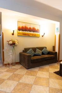 Huanuco Pampa Suite في هانوكو: غرفة معيشة مع أريكة ولوحة على الحائط