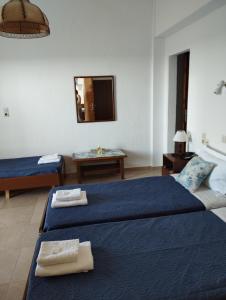 a hotel room with two beds and a mirror at Hotel Kima in Kamariotissa