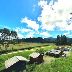 une vue aérienne sur une ferme avec des bâtiments et un champ dans l'établissement Pousada Mato Verde - Urubici - SC, à Urubici