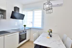 a kitchen with a table with a white counter top at Apartman MAIA in Split