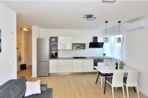 een keuken en een woonkamer met een tafel en een bank bij Apartman MAIA in Split