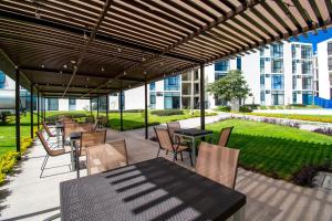a patio with tables and chairs under a pergola at Departamento Tipo Loft, zona ajijic. in Jocotepec