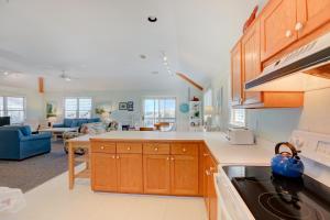 a kitchen with wooden cabinets and a living room at Gray Haven #11-DE in Avon
