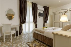 a hotel room with a bed and a desk and a mirror at Da Rita Affittacamere in Pisa