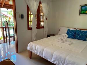 a bedroom with a white bed with a bow on it at CED Villas in El Nido