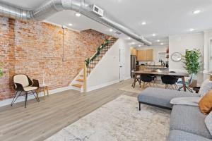an open living room with a brick wall at Loopin Around Atlantic City Luxe 5BR Townhouse in Orange Loop in Atlantic City