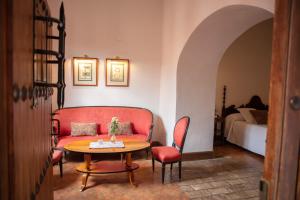 a living room with a red couch and a table at Monasterio de San Francisco in Palma del Río