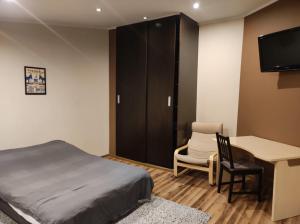 1 dormitorio con cama, escritorio y mesa en City centre studio, en Poznan