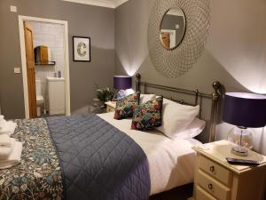 Luxury Self Catering in Colchester في كولشستر: غرفة نوم مع سرير ومرآة على الحائط