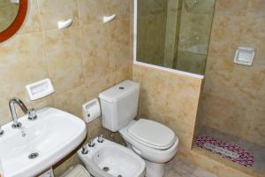 a bathroom with a toilet and a sink and a shower at Hotel El Jardin Dante in Tilcara