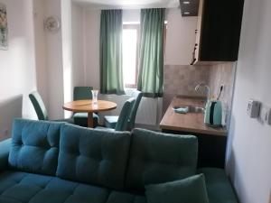 een woonkamer met een blauwe bank en een tafel bij Vila Akva in Jahorina +126 foto's