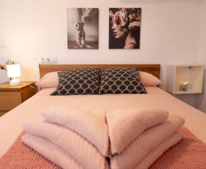 a bedroom with a bed with two pillows and two pictures at Villa al vent (lujo & relax) in Benitachell