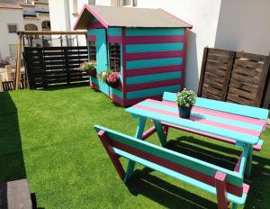 a colorful bench and a play house on the grass at Villa al vent (lujo & relax) in Benitachell