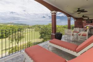 porche con sofá y sillas en el balcón en Bougainvillea 8211 Luxury Apartment - Reserva Conchal, en Playa Conchal