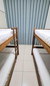 two beds in a room with a striped wall at Apartamento aconchegante, em uma das praias mais bonitas do ES in Serra