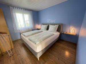 a bedroom with a bed with a blue wall at Gästehaus Durst in Rust