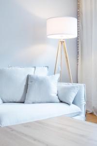 a white couch with pillows and a lamp at Mediterrane Wohnung nahe HBF mit Domblick in Bremen