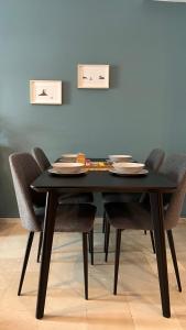 a black table with chairs and plates on it at Theseus Retreat 10 min walk from the Acropolis in Athens