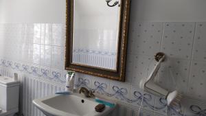 uma casa de banho com um lavatório e um espelho em Domek na wsi 