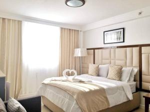 a bedroom with a large bed with a large window at Attractive studio with Luxury bed Good for 1-4pax High speed WiFi with Netflix Free Pool & Parking in Suba