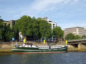 ein grünes Boot auf dem Wasser in einer Stadt in der Unterkunft Küstenmotorschiff Aventura in Bremen