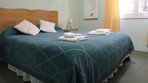 1 dormitorio con 1 cama con toallas en Residencial Sissus en San Carlos de Bariloche