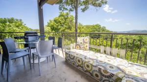 einen Balkon mit einem Sofa, einem Tisch und Stühlen in der Unterkunft Roble Sabana 105 Luxury Apartment - Reserva Conchal in Playa Conchal